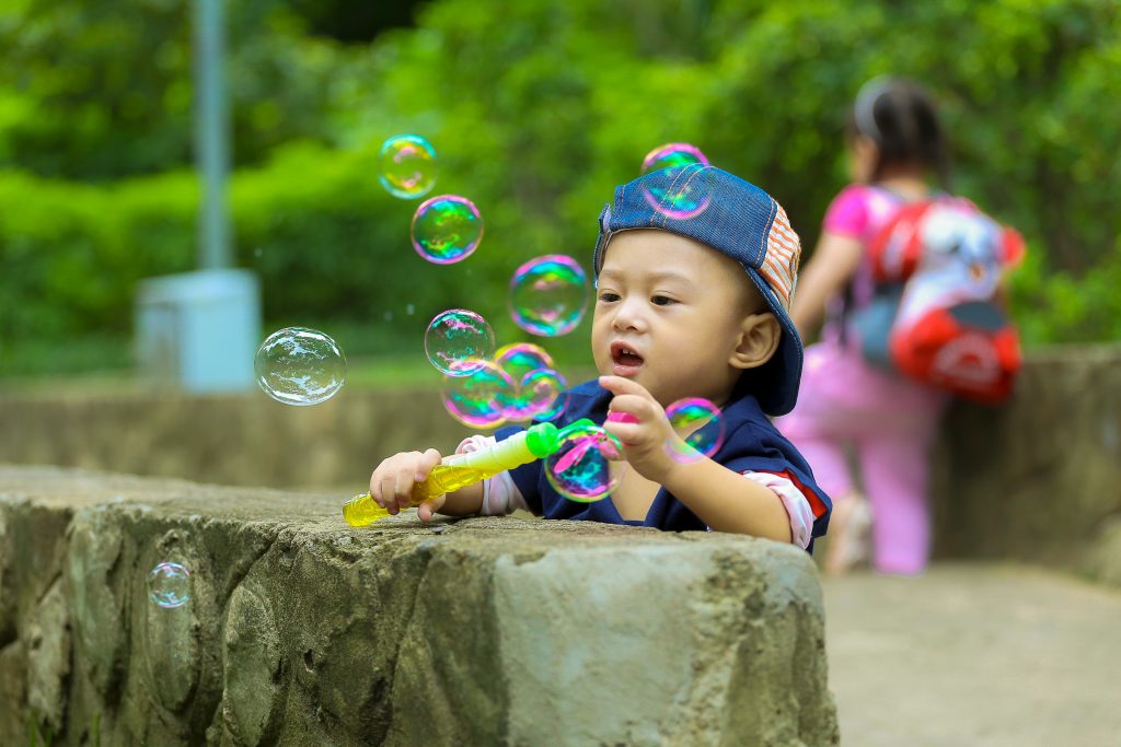 little boy on a family outing with bubbles for some cheap fun