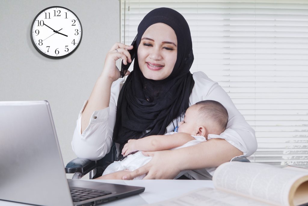Mother with baby working on a laptop for a re-entry program