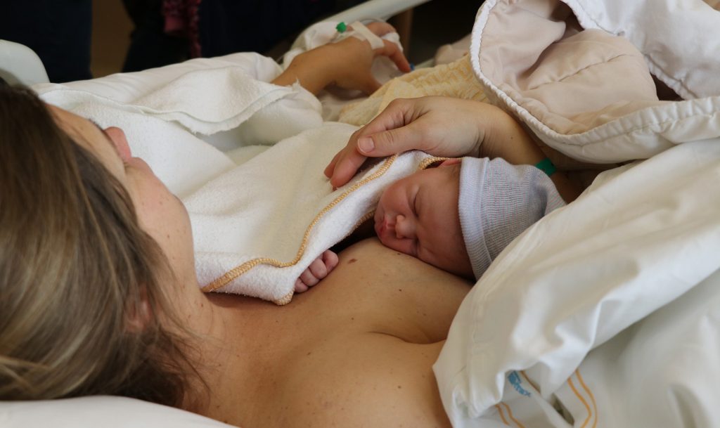 woman holding her newborn in a hospital